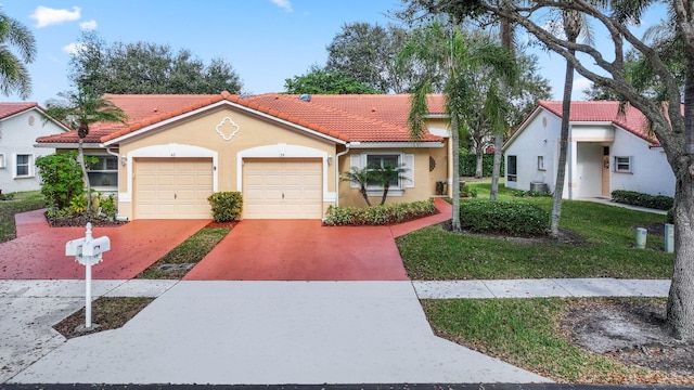 mediterranean / spanish home with central AC, a front yard, and a garage