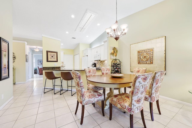 tiled dining area featuring vaulted ceiling and a notable chandelier