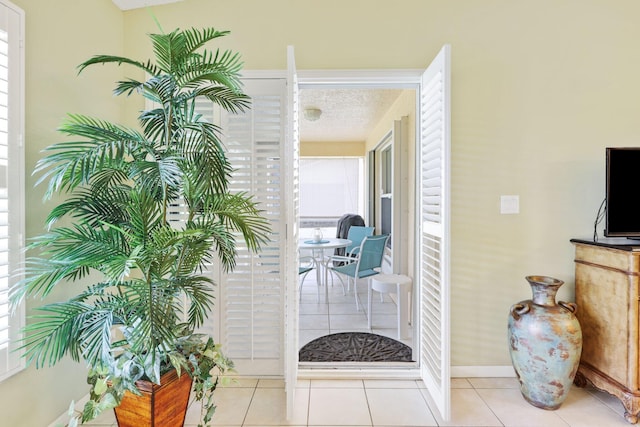 hallway featuring light tile patterned floors and a textured ceiling