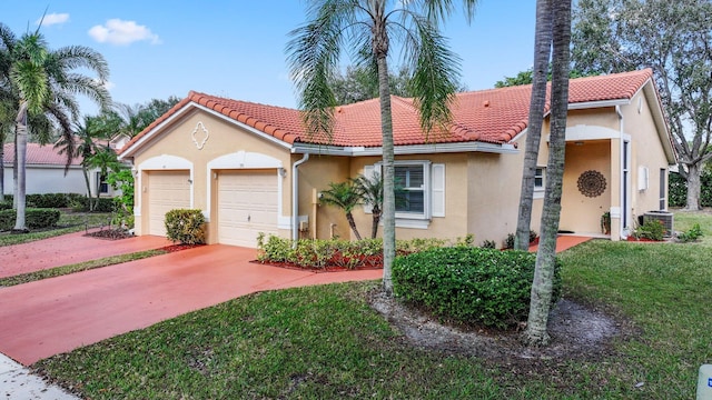 mediterranean / spanish home featuring a front yard, a garage, and central AC unit