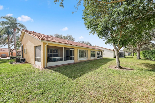 rear view of property featuring central air condition unit and a yard