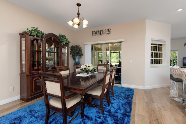 dining area with hardwood / wood-style flooring and an inviting chandelier