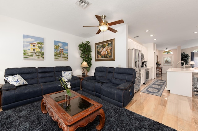 living room with ceiling fan and light hardwood / wood-style floors