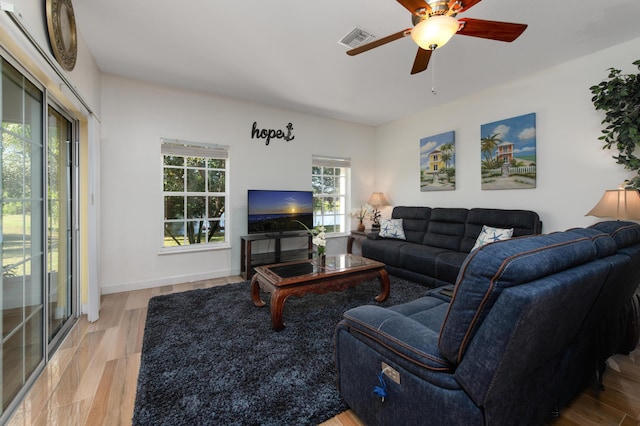 living room featuring a wealth of natural light, light hardwood / wood-style floors, and ceiling fan