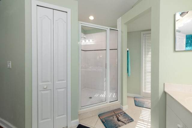 bathroom featuring tile patterned flooring, vanity, and a shower with door