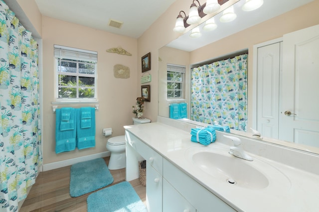 bathroom with curtained shower, toilet, vanity, and hardwood / wood-style flooring