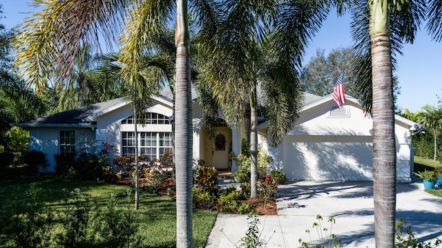 ranch-style home featuring a garage and a front lawn