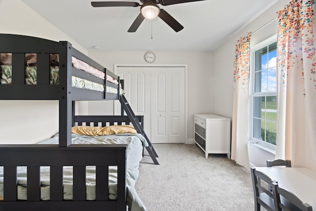 carpeted bedroom featuring ceiling fan and a closet