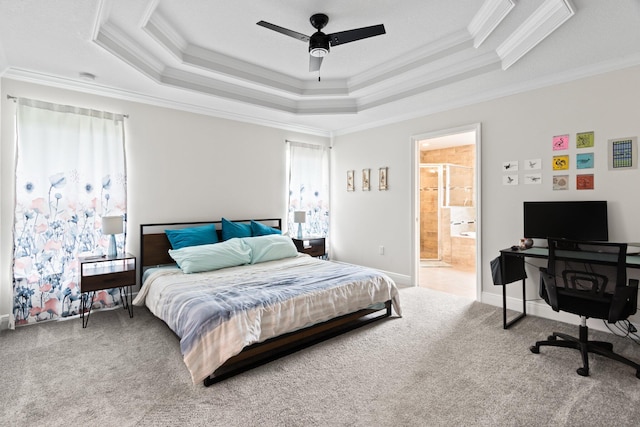 carpeted bedroom featuring ceiling fan, ornamental molding, connected bathroom, and a tray ceiling