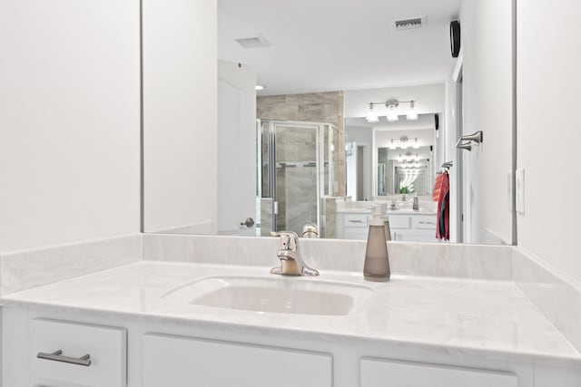 bathroom featuring vanity and a shower with door