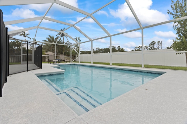 view of pool with a patio and glass enclosure