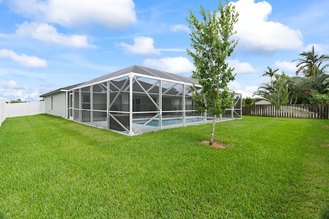 view of yard featuring a fenced in pool and glass enclosure