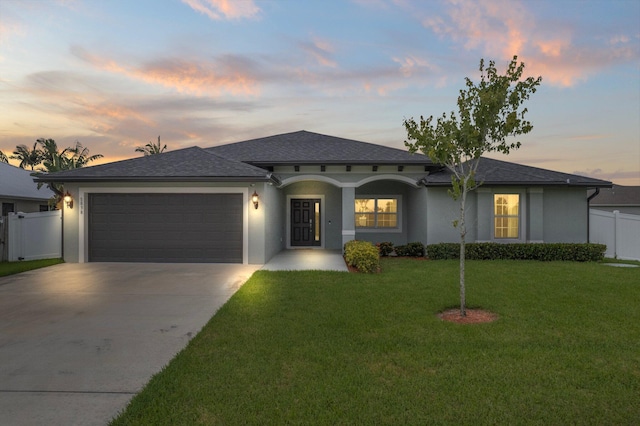 view of front of home featuring a garage and a yard