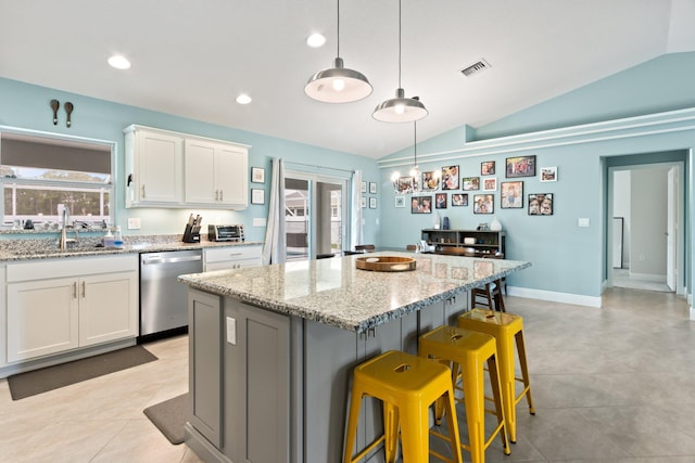 kitchen featuring white cabinets, dishwasher, light stone countertops, and lofted ceiling