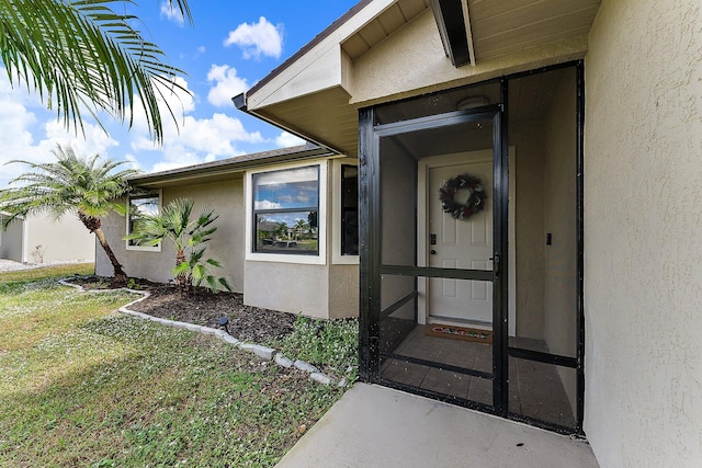 view of exterior entry with a lawn