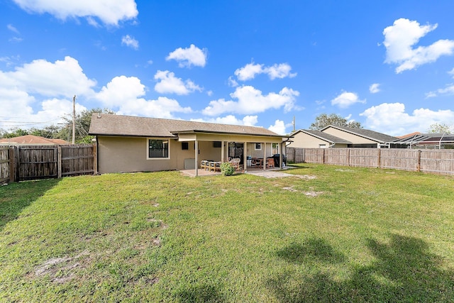 rear view of house featuring a patio area and a yard