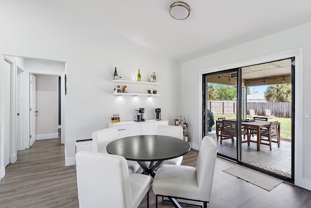 dining space with wood-type flooring and indoor bar