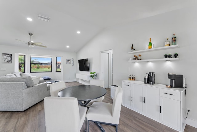 dining room with wood-type flooring, ceiling fan, and lofted ceiling