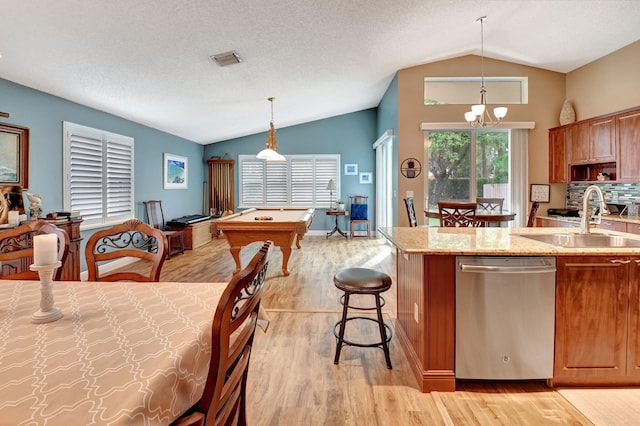 kitchen with stainless steel dishwasher, pendant lighting, pool table, and vaulted ceiling