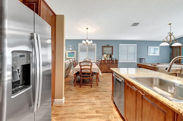 kitchen featuring a chandelier, appliances with stainless steel finishes, decorative light fixtures, and sink