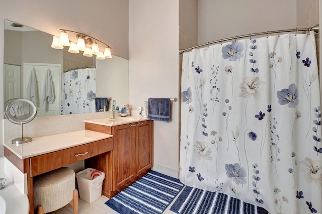 bathroom with tile patterned flooring, vanity, and walk in shower