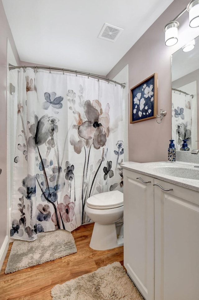 bathroom with vanity, curtained shower, toilet, and wood-type flooring