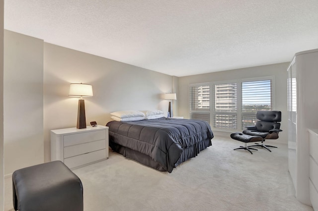 bedroom with light colored carpet and a textured ceiling