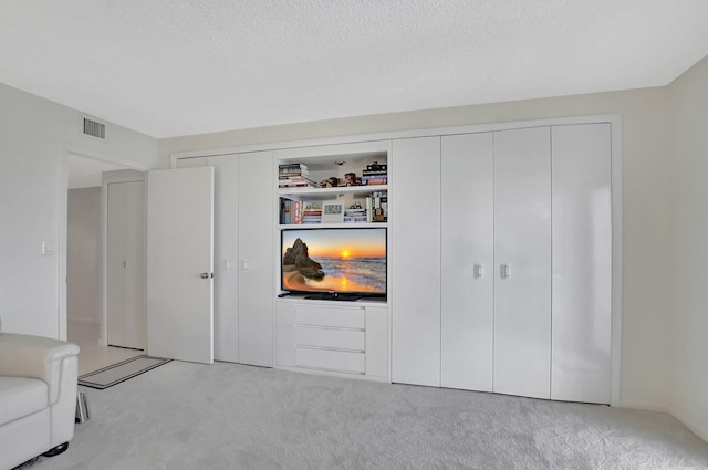 carpeted living room featuring a textured ceiling