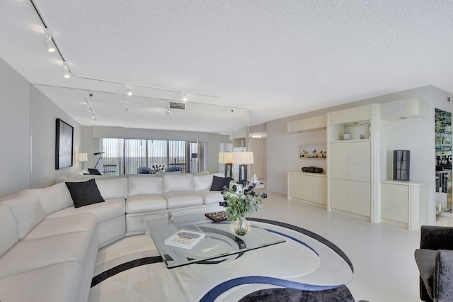 living room with a wall mounted air conditioner and a textured ceiling