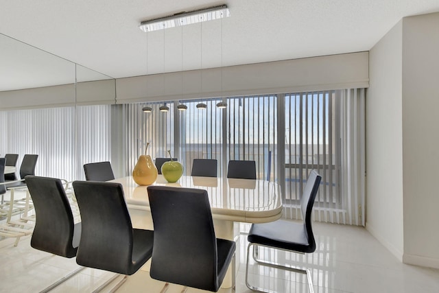 tiled dining space featuring a textured ceiling