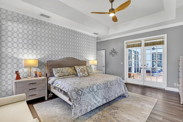 bedroom featuring access to exterior, ceiling fan, french doors, dark hardwood / wood-style floors, and a tray ceiling