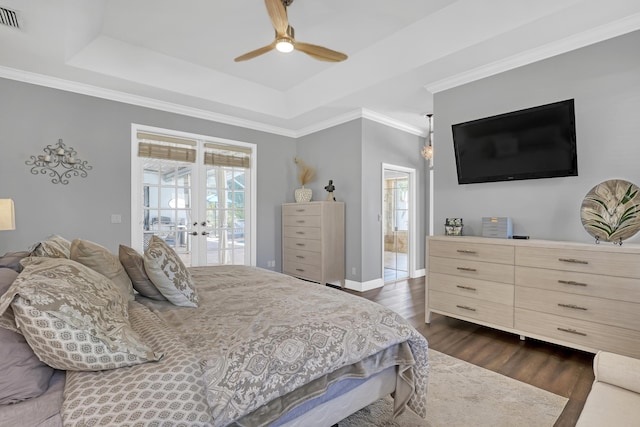 bedroom with a tray ceiling, ceiling fan, dark hardwood / wood-style floors, and access to outside