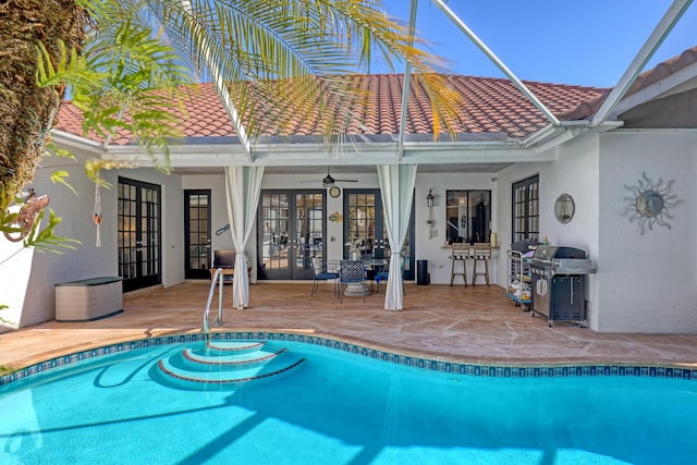 view of swimming pool featuring ceiling fan, area for grilling, a patio, and french doors