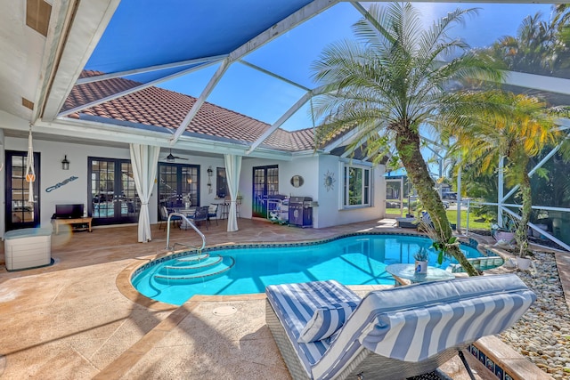 view of pool featuring a lanai, a patio area, ceiling fan, and french doors