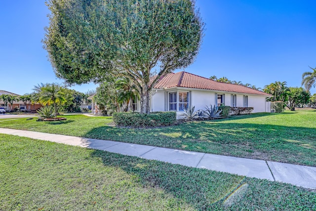 15591 Milan Ct, Wellington, FL 33414 - ranch-style home with stucco siding, a front lawn, and a tile roof