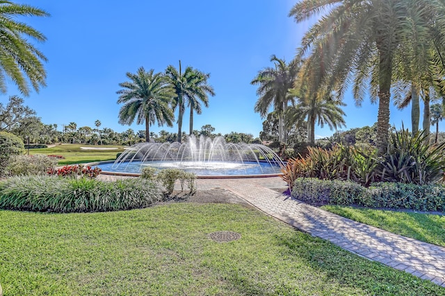 view of property's community with a water view and a lawn