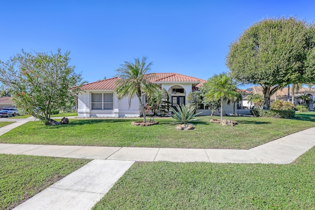 15591 Milan Ct, Wellington, FL 33414 - mediterranean / spanish-style home with a front lawn, stucco siding, and a tile roof