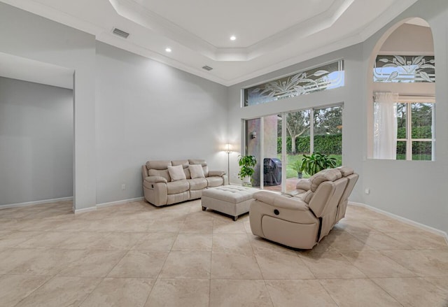 living room with a high ceiling, a tray ceiling, and crown molding