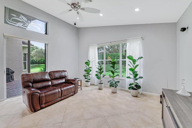 living room with ceiling fan, light tile patterned floors, and lofted ceiling