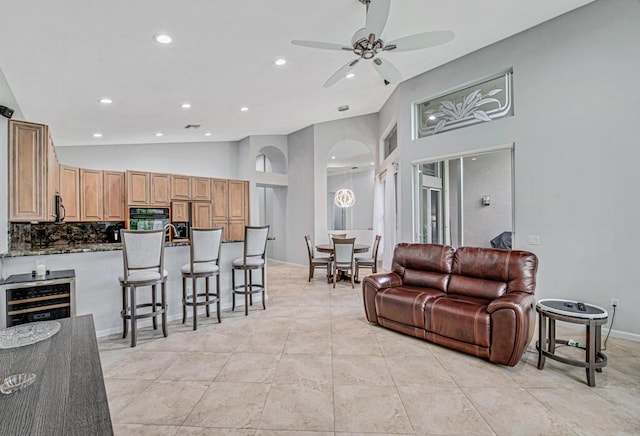 living room featuring wine cooler, ceiling fan, and lofted ceiling