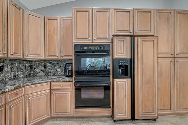 kitchen featuring backsplash, dark stone countertops, black double oven, lofted ceiling, and light tile patterned floors