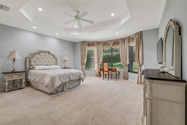 bedroom featuring ceiling fan, a raised ceiling, ornamental molding, and light carpet