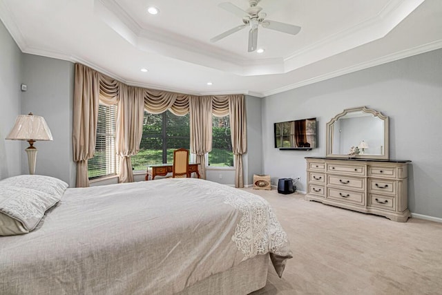 bedroom featuring ceiling fan, a raised ceiling, light colored carpet, and ornamental molding