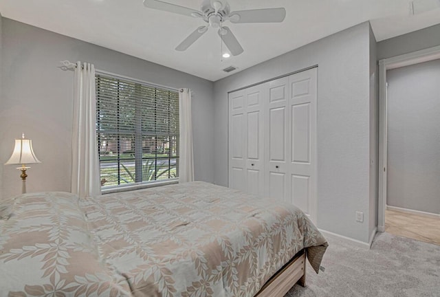 carpeted bedroom with ceiling fan and a closet