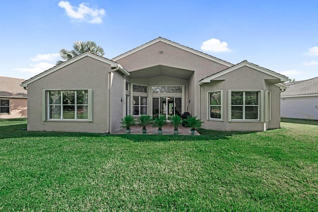 rear view of property featuring a lawn