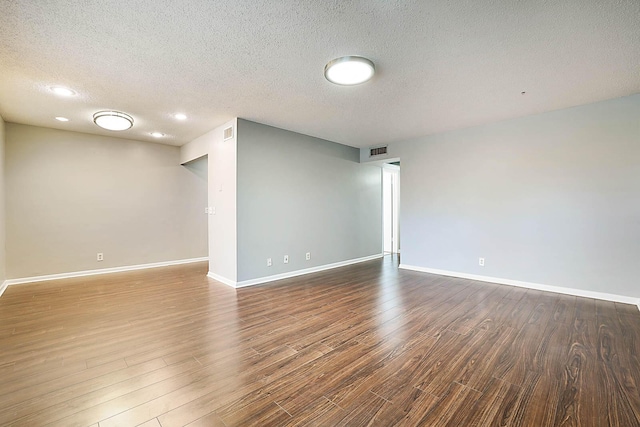 empty room with a textured ceiling and hardwood / wood-style flooring