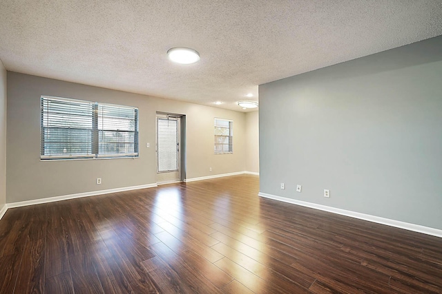 unfurnished room with a textured ceiling and dark hardwood / wood-style floors