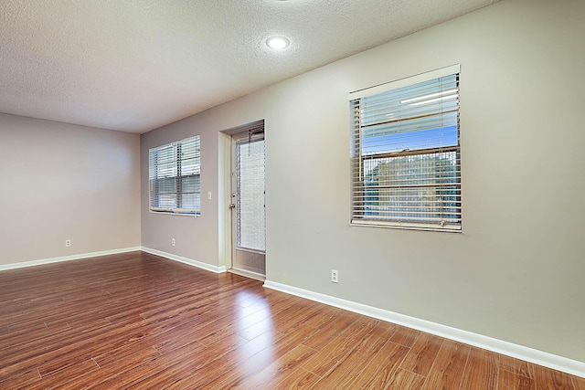 spare room with hardwood / wood-style floors and a textured ceiling