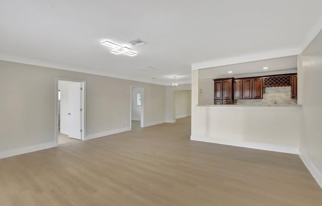 unfurnished living room featuring light hardwood / wood-style floors and a chandelier