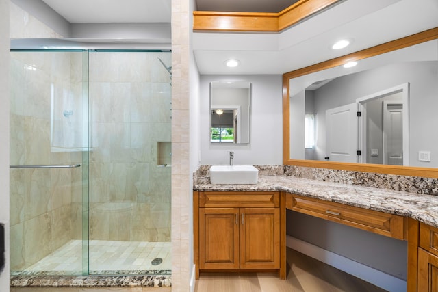 bathroom with vanity, hardwood / wood-style flooring, and walk in shower